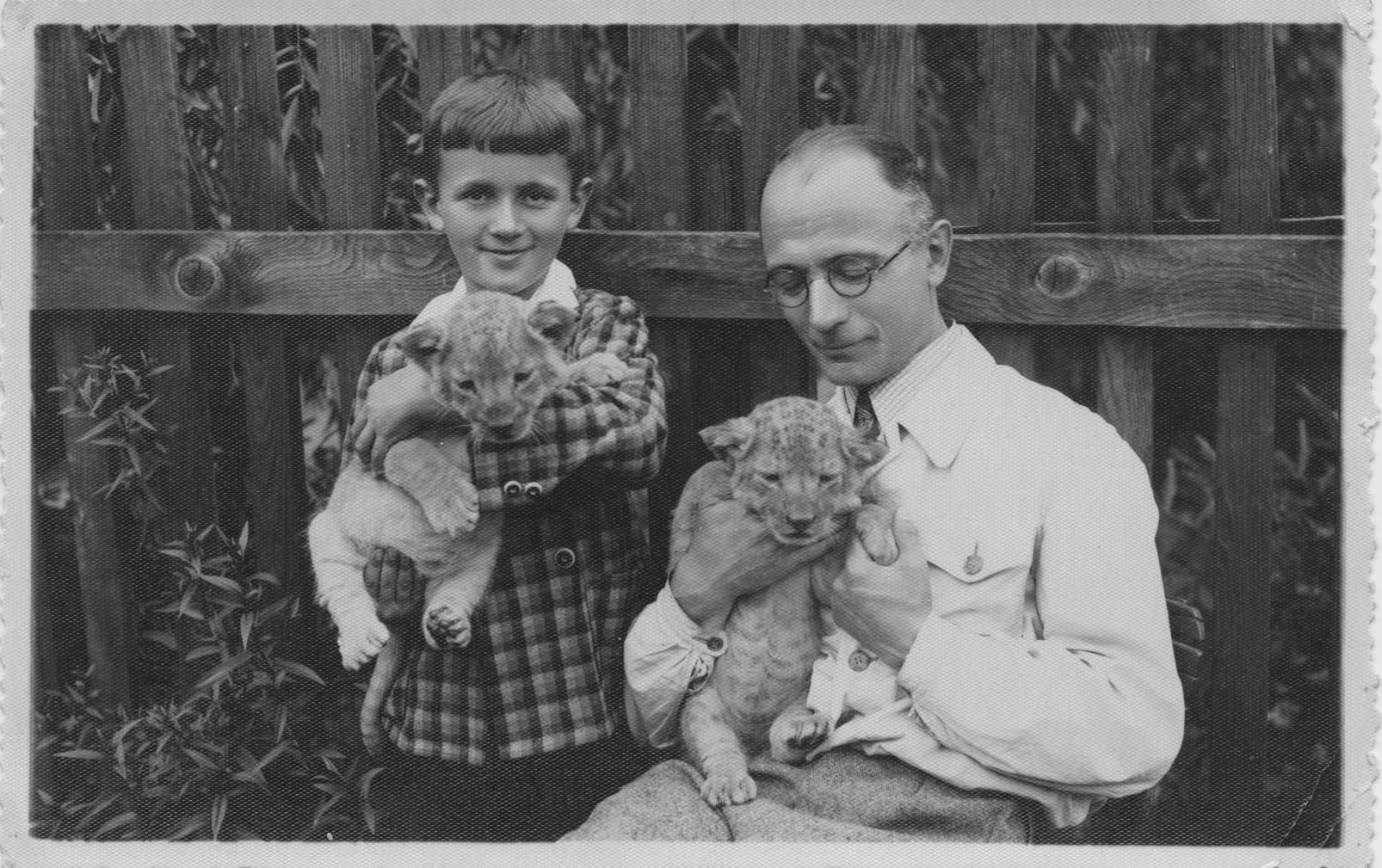 Fotografia przedstawia chłopca i mężczyznę trzymających młode lwiątka? 